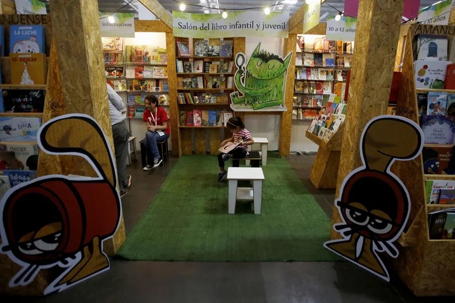 Un niño lee un libro.