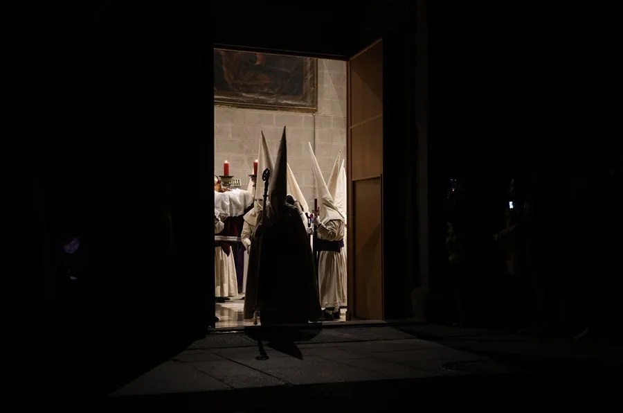 Un nazareno de la Penitente Hermandad de Jesús Yacente a la salida del templo durante la procesión del paso de Jesús Yacente en la madrugada de este viernes en Zamora.