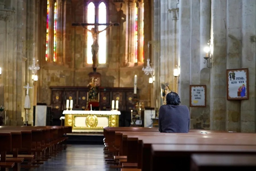 Un hombre reza en la iglesia de Santa Marina