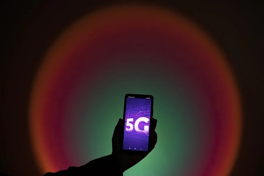 Una persona sostiene hoy un móvil con una imagen de la nueva tecnología 5G