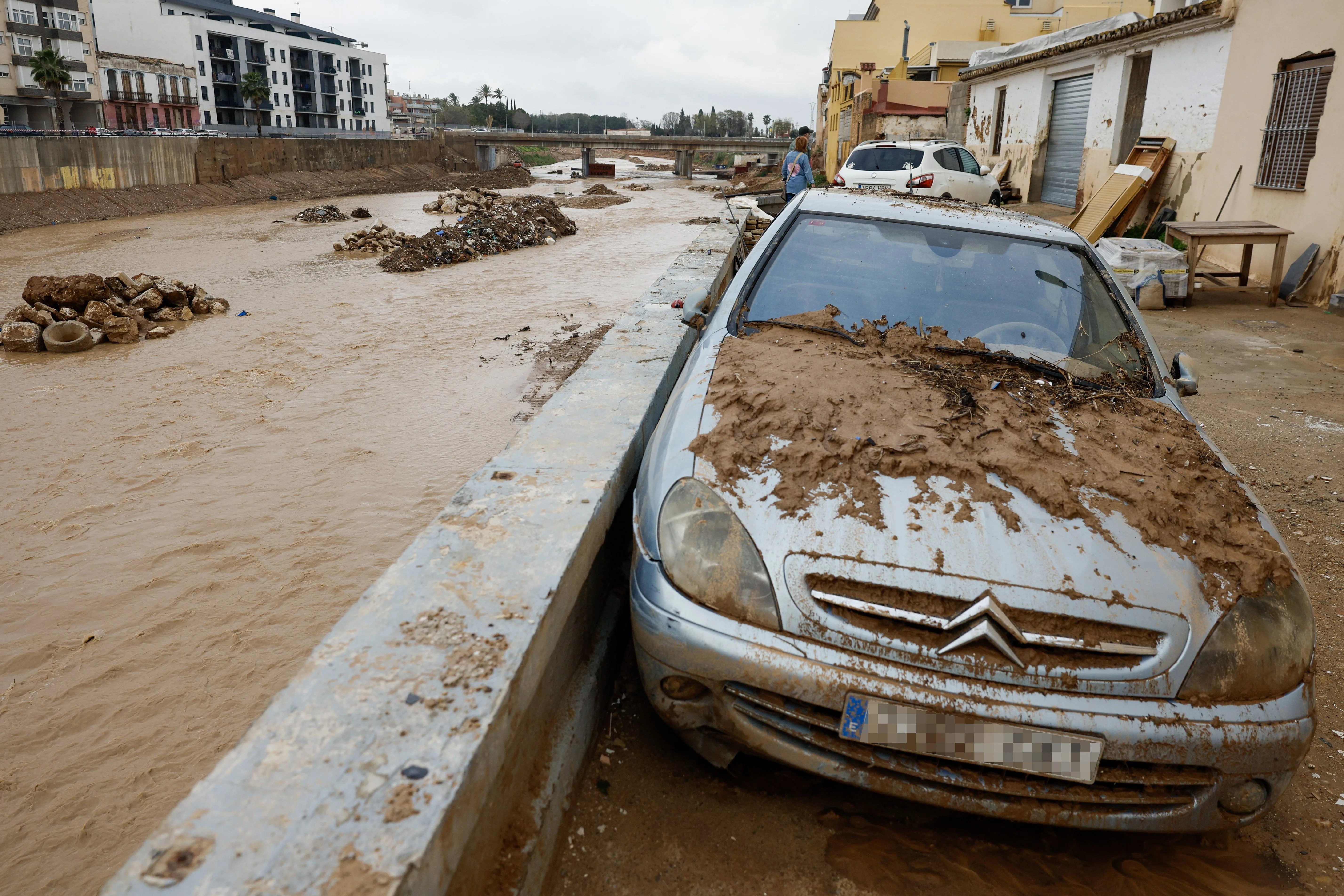 Vehículos cubiertos de barro e inmuebles destrozados junto al barranco del Poyo en Paiporta, en una imagen de archivo