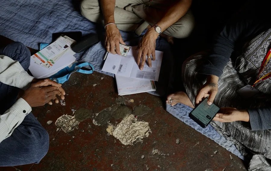 Miembros de la Autoridad del Gran Bengaluru (GBA), que comprende cinco corporaciones municipales, recopilan información de familiares como parte del censo de castas en la colonia Gulbarga en Bangalore