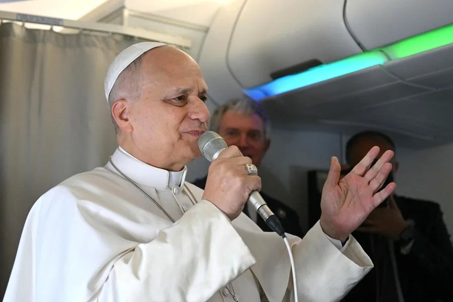 El Papa León XIV (izq.) habla con periodistas a bordo de su vuelo con destino a Argel
