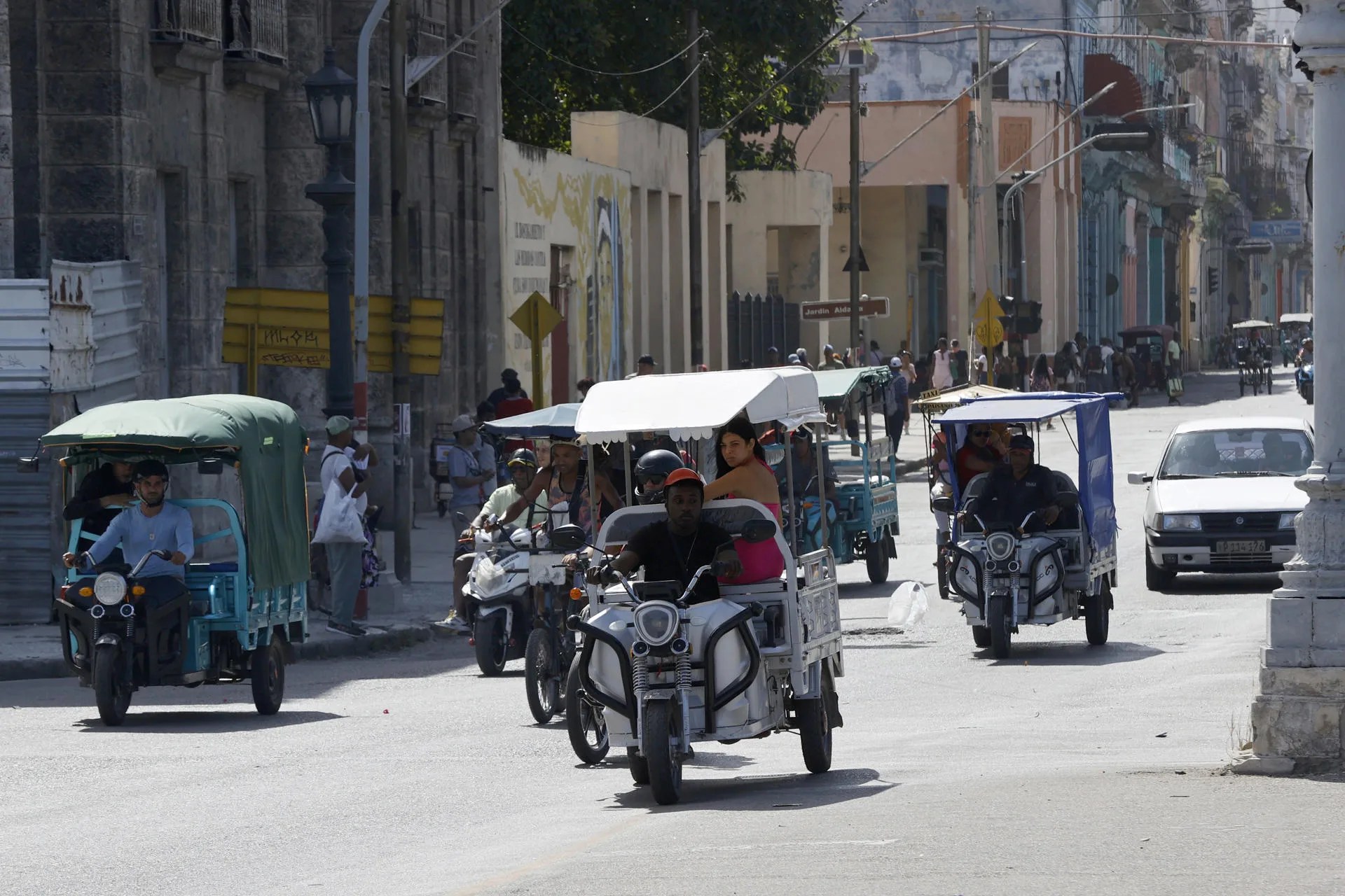 People travel on electric tricycles on March 31, 2026 in Havana, Cuba issued April 04, 2026. Havana is currently dominated by various and creative electric vehicles, such as cargo tricycles adapted for passengers, which serve as an alternative to gasoline-powered vehicles amid the island's severe energy crisis. EFE/Ernesto Mastrascusa
