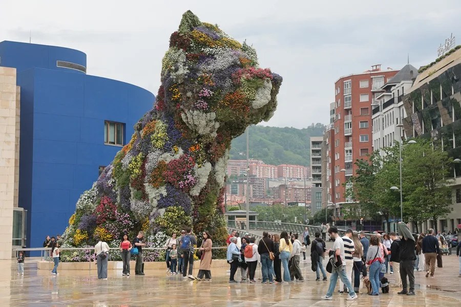 Turistas junto a la escultura de Puppy, en el museo Guggenheim