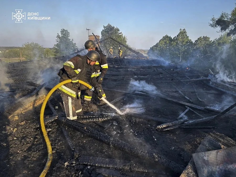 rescatistas ucranianos trabajando en el lugar donde los restos de un dron ruso interceptado cayeron sobre el techo de una guardería en la región de Fastiv, cerca de Kiev