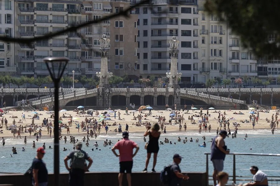 Bañistas disfrutan de un día veraniego en la bahía de la Concha de San Sebastián.