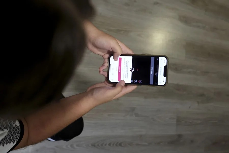 Una chica consulta su teléfono móvil.