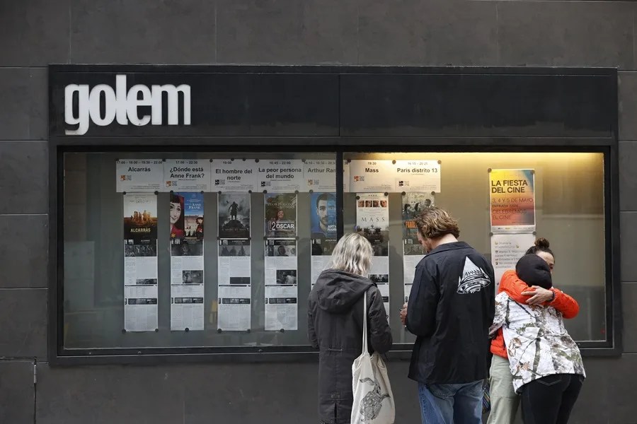 Espectadores observan la cartelera de un cine en Madrid.