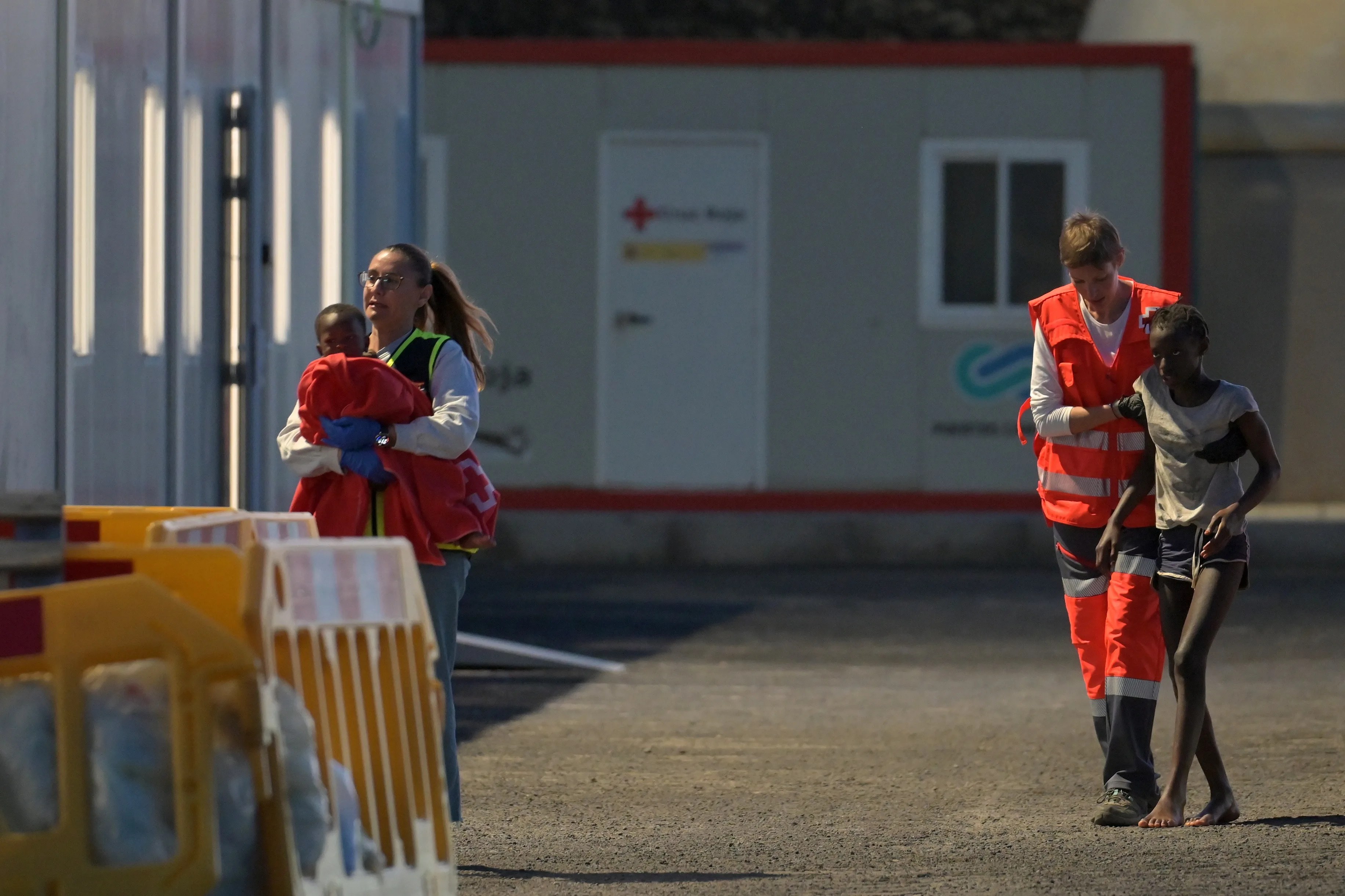 Personal de la Cruz Roja ayuda a dos de los menores del cayuco a su llegada al puerto de La Restinga. EFE/Gelmert Finol