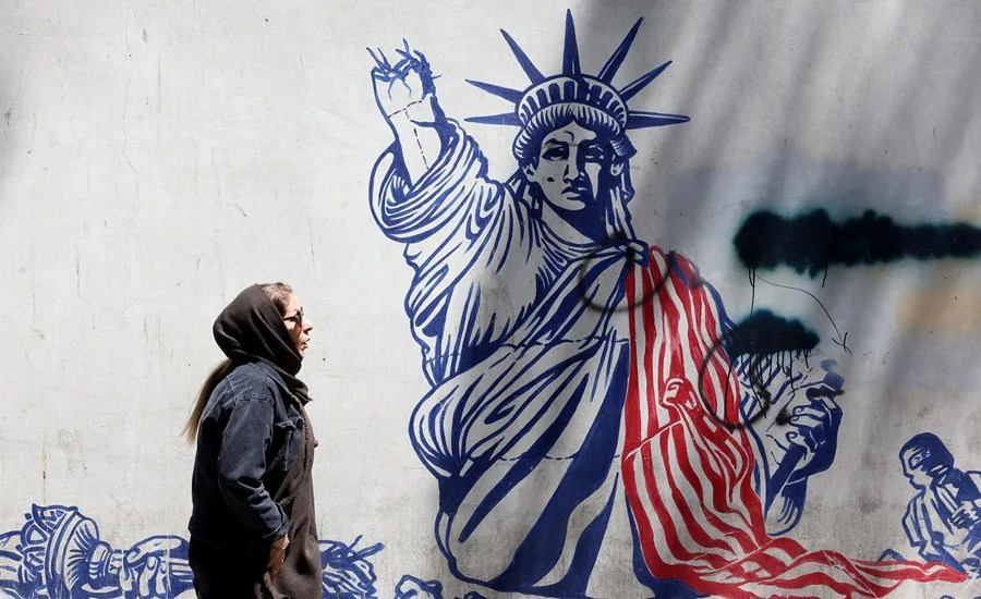 Una mujer iraní camina junto a un mural antiestadounidense cerca de la antigua embajada de Estados Unidos en Teherán