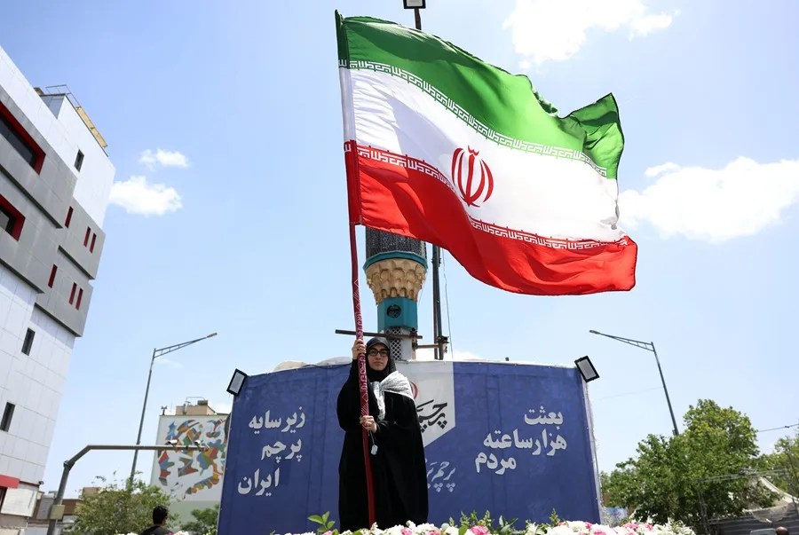 Una mujer con una bandera de Irán, hoy en Teherán.