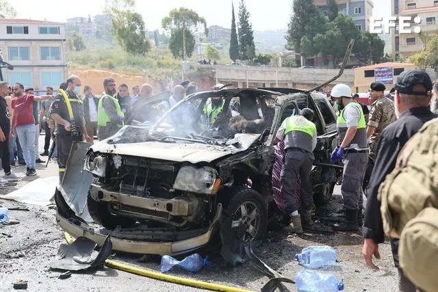 Rescatistas y soldados libaneses inspeccionan los restos de un vehículo alcanzado por un ataque israelí en la ciudad de Jiyeh, al sur de Beirut