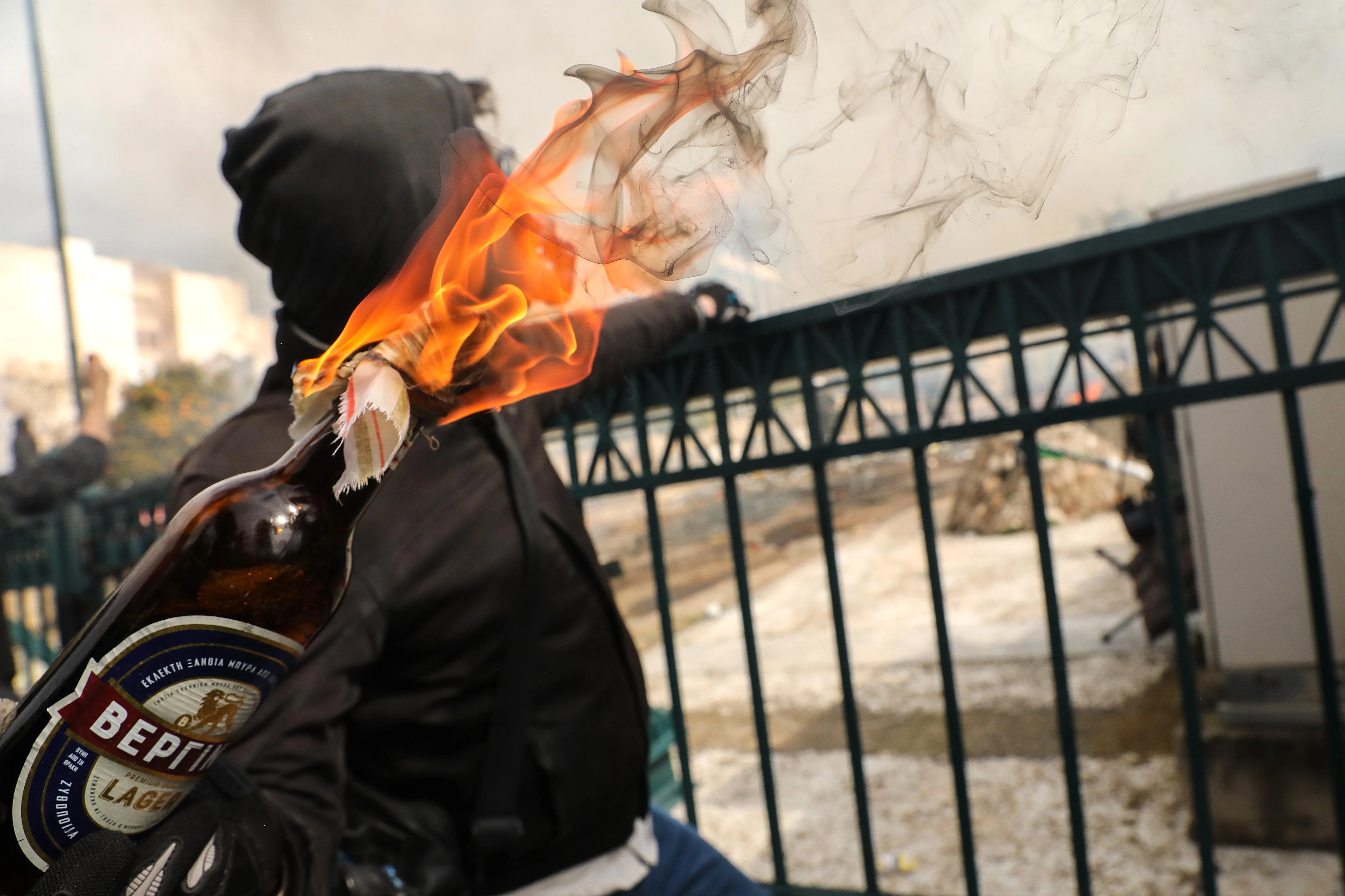 Una manifestante lanza un cóctel molotov.