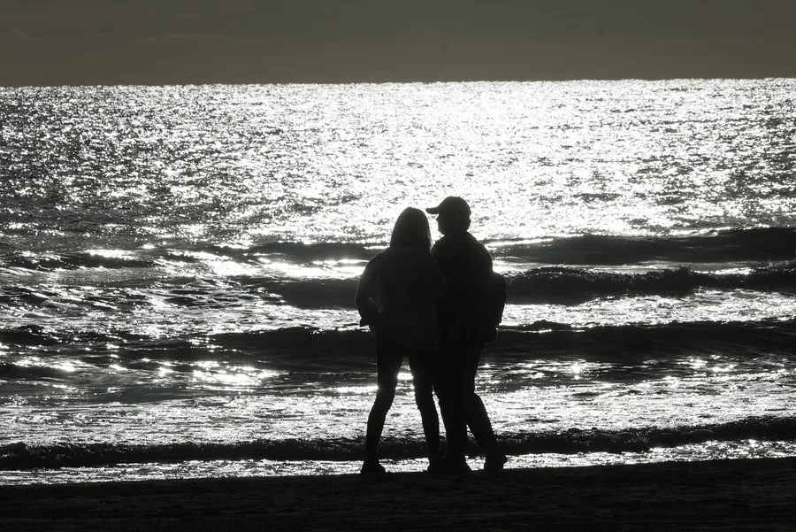 Una pareja pasea en la playa de la Malvarrosa