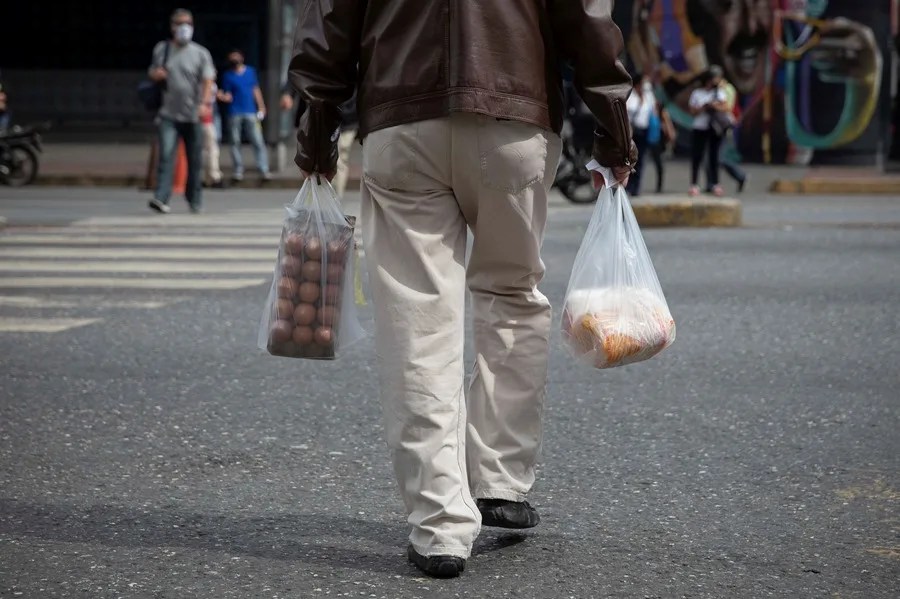 Un hombre camina con bolsas de compra