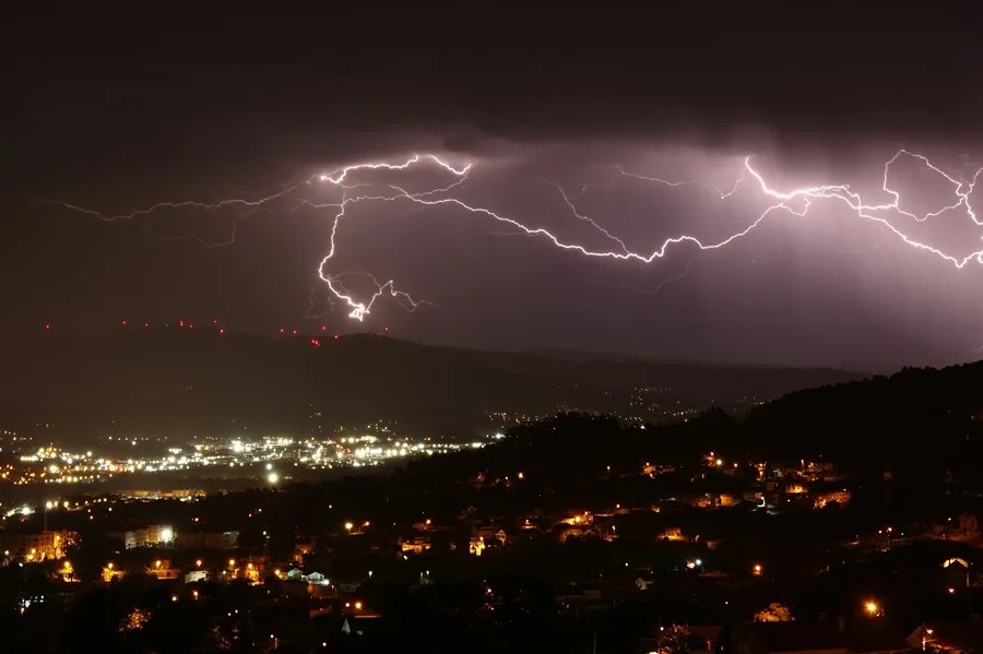 Rayos descargan sobre Vigo durante una tormenta eléctrica en una imagen tomada en el Alto de Puxeiros hacia el Val de Louriña