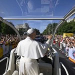 El papa León XIV saluda desde el papa móvil camino a la plaza Cibeles para oficiar la misa del Corpus Christi, en Madrid.