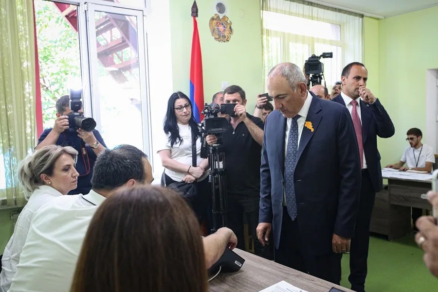 El líder del partido Contrato Civil y primer ministro interino de Armenia, Nikol Pashinyan (2-D), llega a un colegio electoral en Ereván