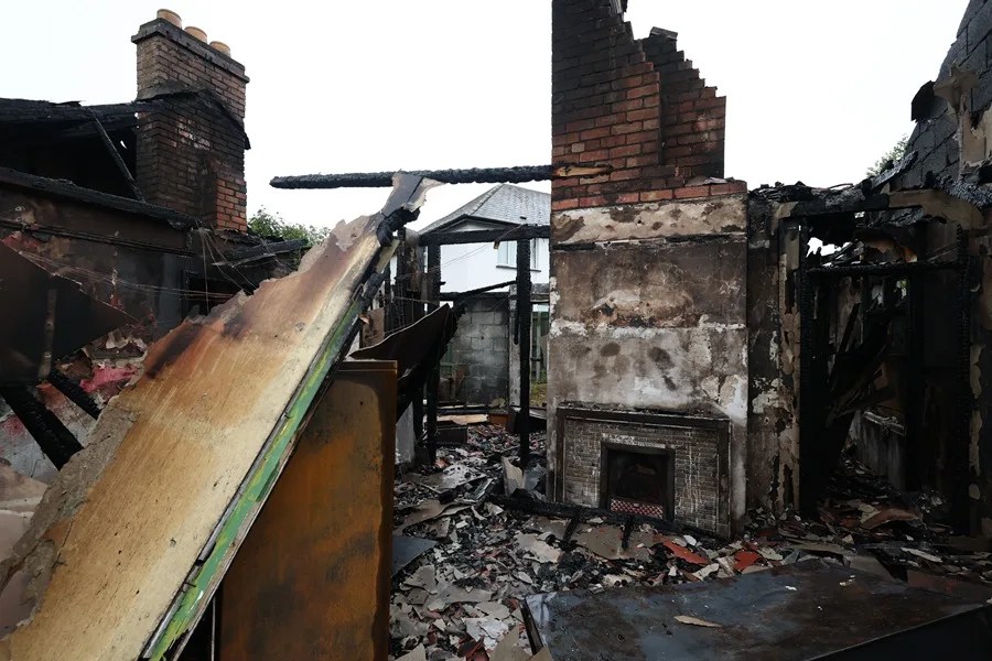 Una casa incendiada tras una noche de disturbios violentos en Antrim Road, en Newtownabbey, Irlanda del Norte