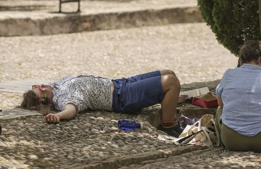 Un turista descansa a la sombra de un árbol en el Patio de los Naranjos, en Córdoba