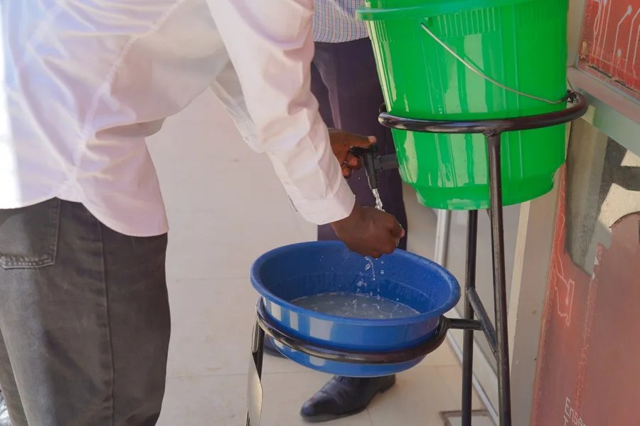 Un hombre se lava las manos en agua con desifectante para evitar contagios de ébola en Bunia. E
