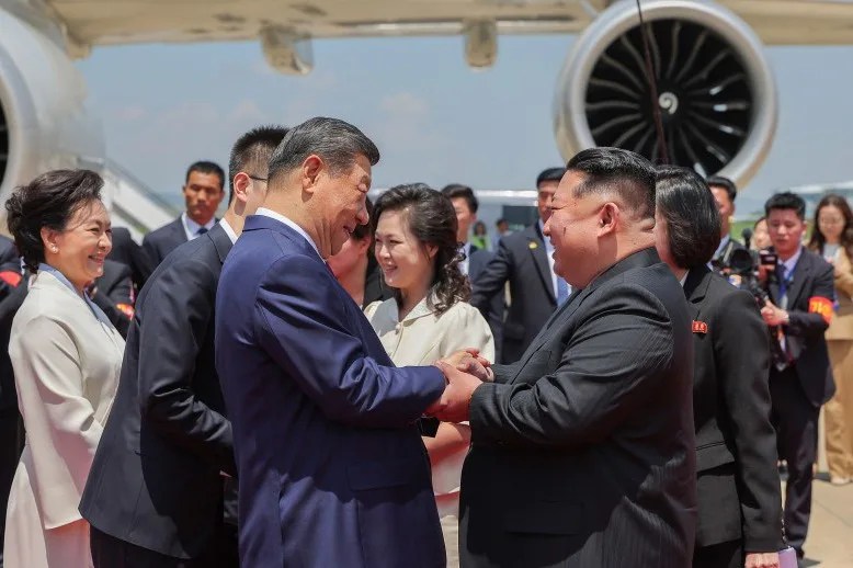 El líder norcoreano, Kim Jong-un (d), saluda al presidente chino, Xi Jinping