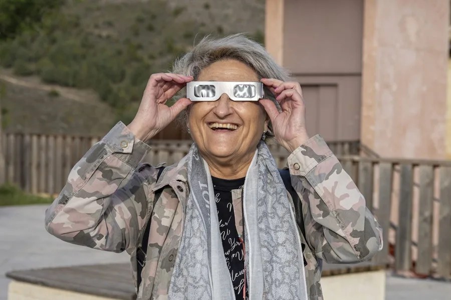 Una mujer observa un eclipse con unas gafas especiales.