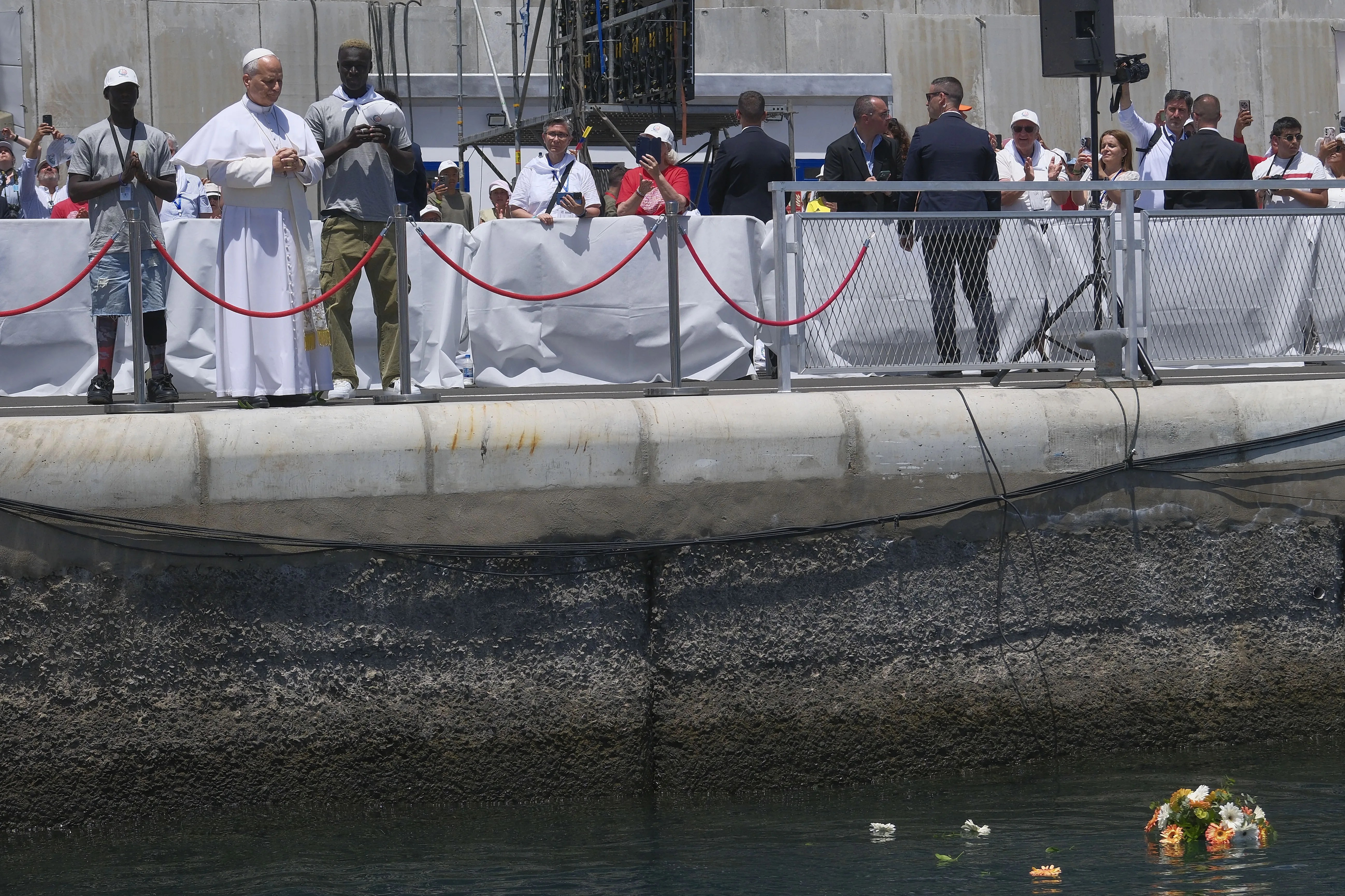 El papa León XIV lanza un ramo de flores al mar en recuerdo de los migrantes que han perdido la vida en el Atlántico. EFE/Ángel Medina G.