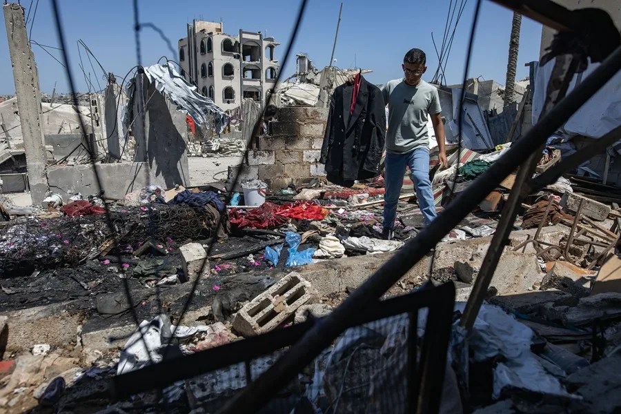 Un hombre camina portando la chaqueta de boda del palestino Muhannad Farwana, quien murió en un bombardeo israelí