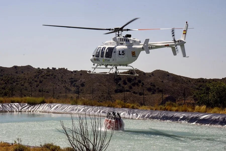 Un helicóptero recoge agua para extinguir el incendio que surgió en el término de Tamarite de Litera que ha arrasado más de mil hectáreas