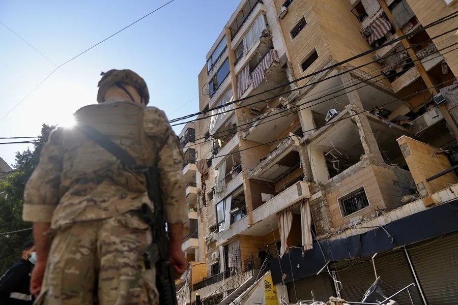 Un soldado del ejército se encuentra en el lugar de un ataque aéreo israelí contra un apartamento en los suburbios del sur de Beirut
