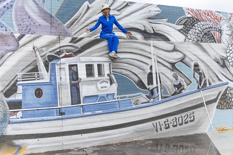 La muralista Lula Goce posa junto a su mural durante una entrevista con EFE.