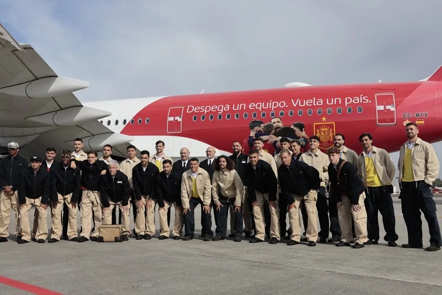 Los jugadores y el cuerpo técnico de la selección española posan ante el avión que llevará al equipo a EEUU