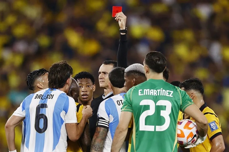 El futbolista argentino Nicolás Otamendi (c) recibiendo una tarjeta roja del arbitro Wilmar Roldán, durante un partido de las eliminatorias sudamericanas del Mundial 2026 contra Ecuador.