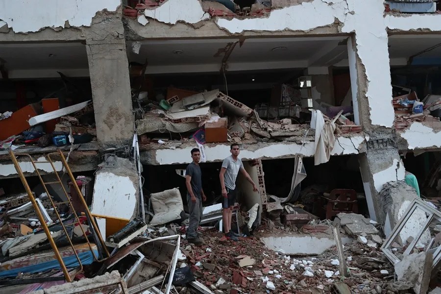Residentes buscan entre los escombros de uno de los edificios de apartamentos que colapsaron durante los terremotos en Catia la Mar