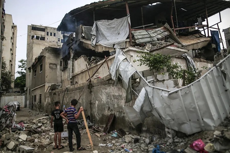 Dos jóvenes frente a una casa destruida tras un ataque israelí, en la ciudad de Gaza, Franja de Gaza.