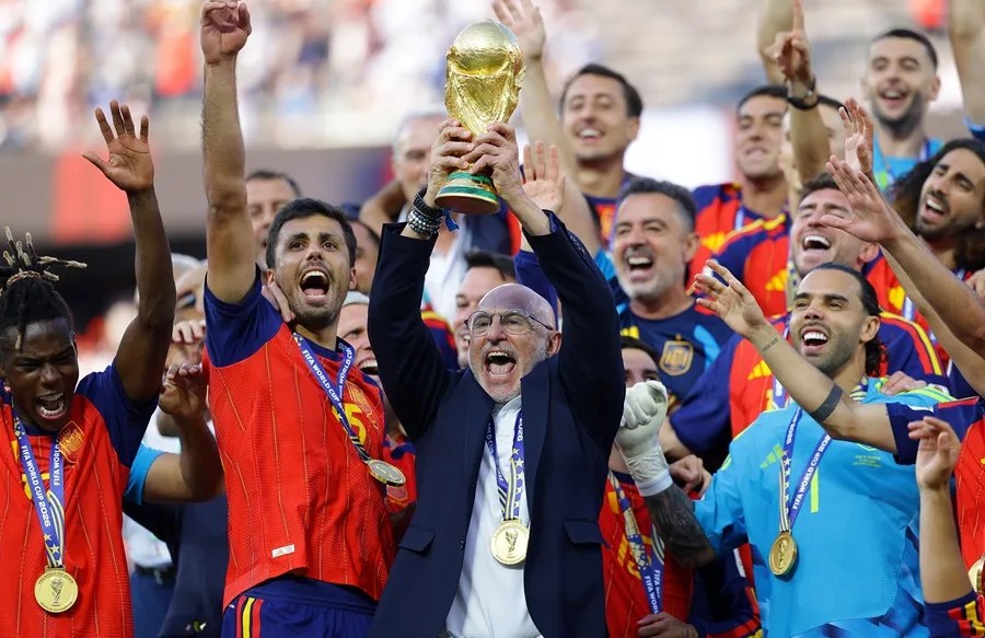 El seleccionador español, Luis de la Fuente, alza el trofeo de la Copa del Mundo mientras el equipo celebra la victoria en la final de la Copa del Mundo de la FIFA 2026 entre España y Argentina. EFE/EPA/CHRISTOPHER NEUNDORF