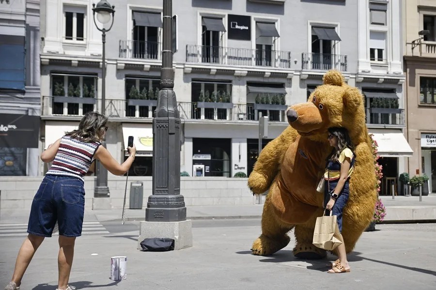 Una mujer se hace una foto con una mascota en el centro de Madrid.