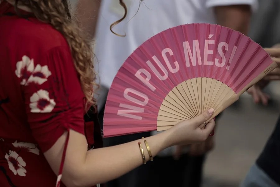 Una mujer combate el calor con un abanico con el lema "No puc més!" (No puedo más!)