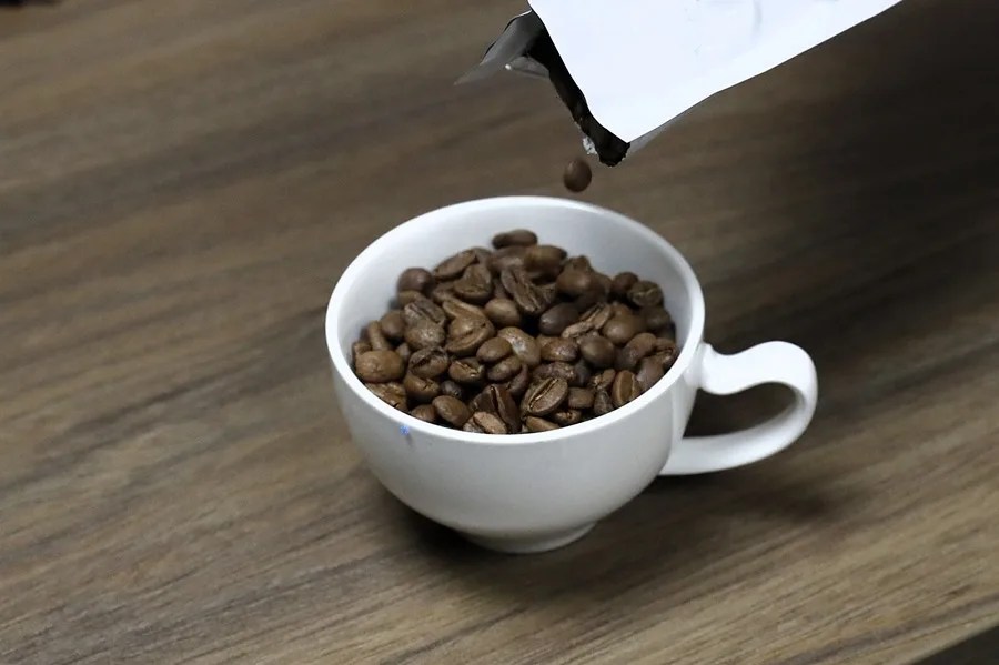 Fotografía de archivo de una taza con granos de café.
