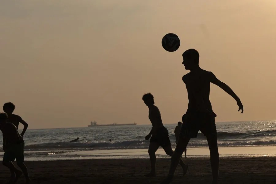 Jóvenes juegan al fútbol en la playa vizcaína de Sopelana