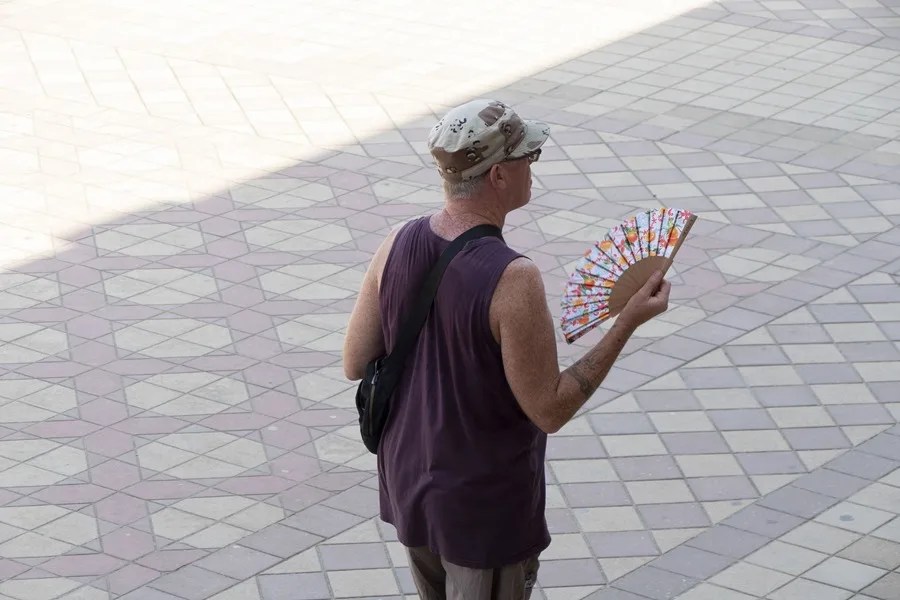 Un turista se abanica en Sevilla.