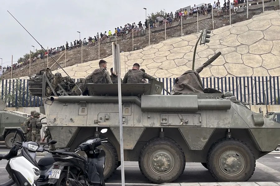 El ejército desplegando en la frontera del Tarajal en Ceuta ante la atenta mirada de los inmigrantes este viernes.