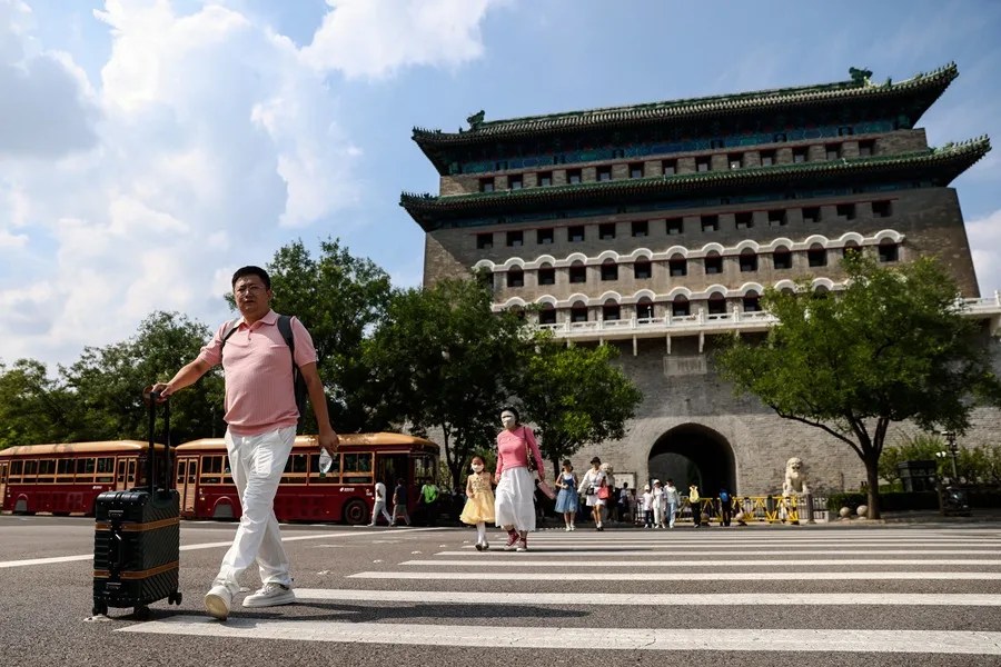 Turistas pasean por la calle Qianmen en Pekín, China