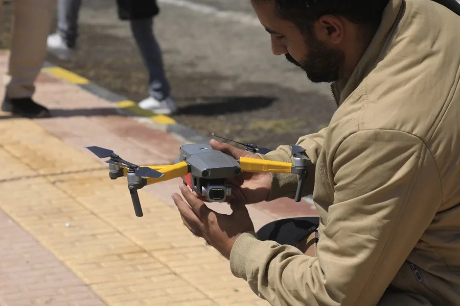 Un operador de cámara sostiene un dron a