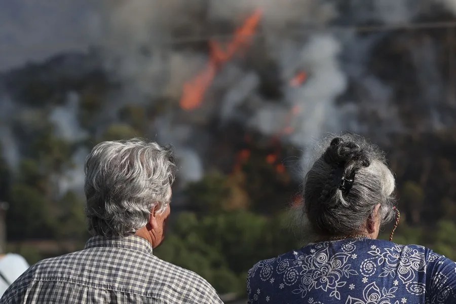 Dos personas observan un incendio en la localidad lucense de Ribas de Sil (España).