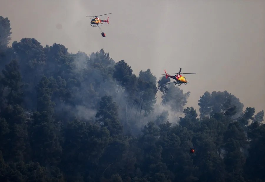 Dos helicópteros de extinción de incendios lanzan agua sobre un incendio forestal en la localidad de Sentmenat