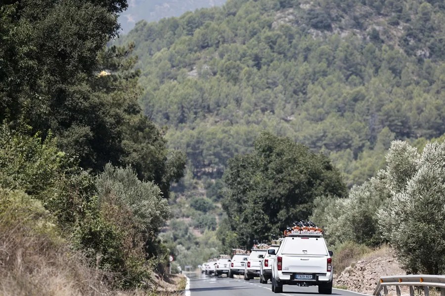Numerosos vehículos de brigadistas forestales en una carretera de Artana (Castellón).