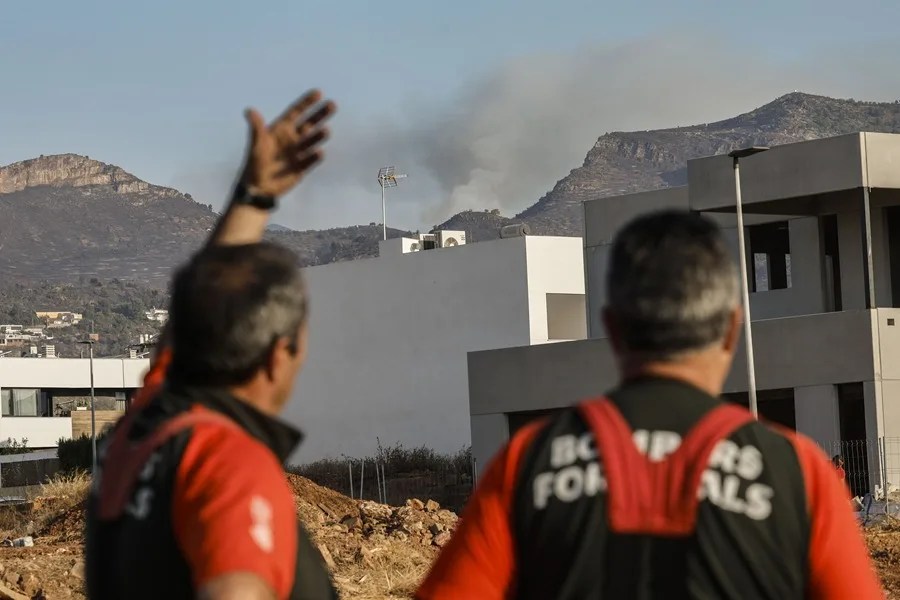 Bomberos forestales contemplan el incendio desde el puesto de mando de Vall d'Uixó este miércoles